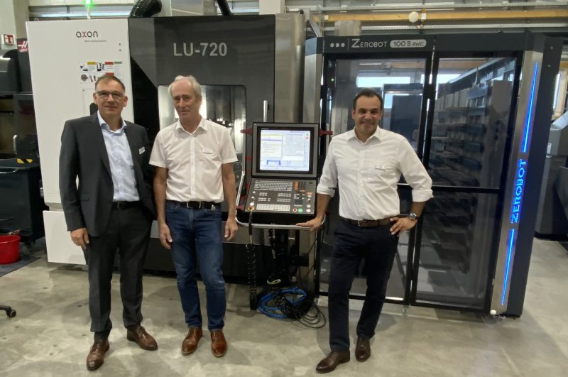 Jürgen Widmann (Evo) und Klaus Hofmann sowie Mario Sanna (Zeroclamp) vor einer automatisierten Werkzeugmaschine (Bild: Evo).