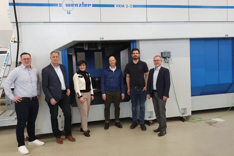 Haben für das anspruchsvolle Projekt ihr Know-how gebündelt (v. l.): Igor Ivankovic und Peter Krafft (Mapal), Ingrid und Wolfgang Wenzler sowie Sebastian Knaus (Wenzler) und Sven Frank (Mapal). Im Hintergrund eine Maschine des Typs »VKM 2-2« mit jeweils zwei Spindeln und zwei autarken Kammern (Bild: Mapal).