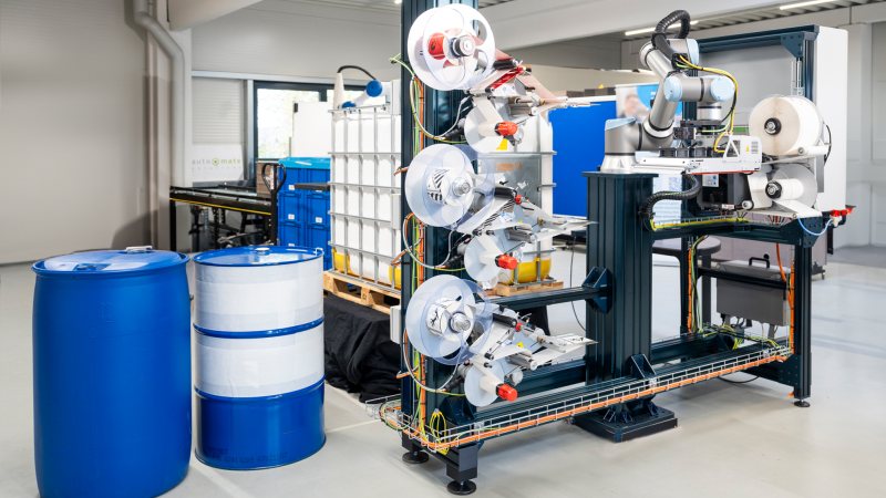 Die vollautomatische Etikettieranlage arbeitet mit Cobot, vier Etikettiersystemen und einem robotergeführten Riemenapplikator (Bild: Bluhm Systeme).