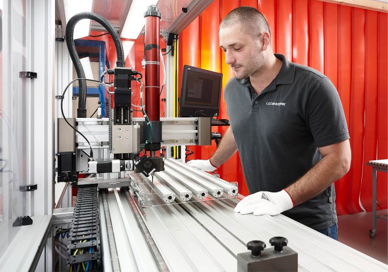 Sicher, sauber und teilautomatisiert: Mit dem Kleberoboter werden die Schutzscheiben über dem Lichtaustritt der LED-Industrieleuchte präzise und dauerhaft fixiert (Bild: LED2Work).