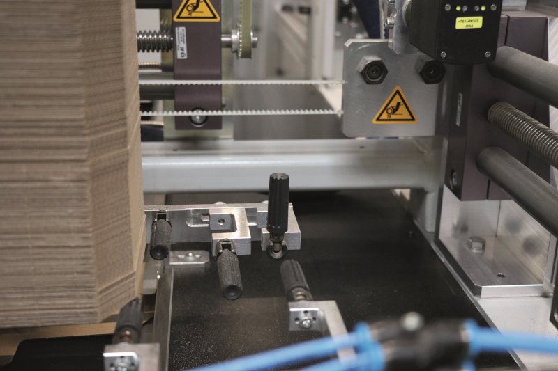 Das Verpackungsmaterial wird im Regelfall zugeführt, beispielsweise in Magazinen, anschließend aufgerichtet und in vielen Fällen mittels Label-Drucker beschriftet. Zylindergriffe von KIPP sind die geeignete Lösung, um den Prozess reibungslos zu gestalten (Bild: Kipp).